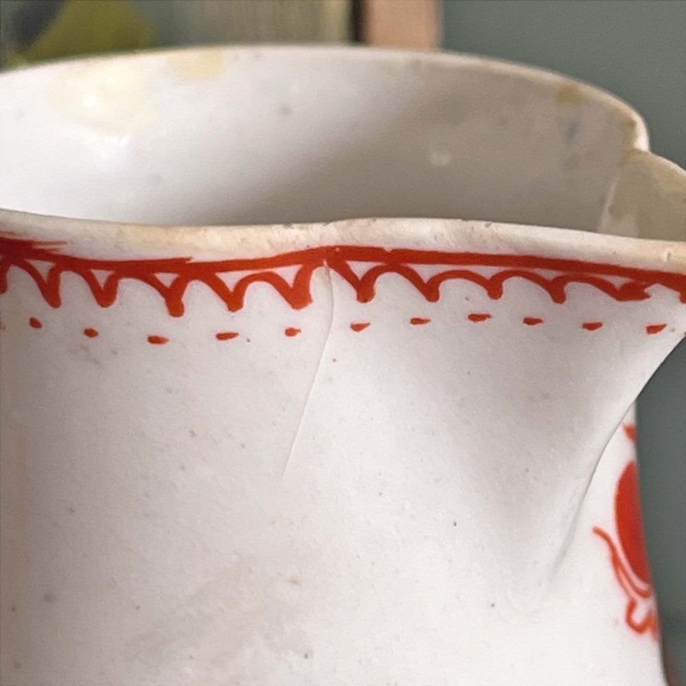 An eighteenth-century Bow soft-paste porcelain sparrowbeak cream jug hand-painted with polychrome floral sprigs and a red painted border. View VIII