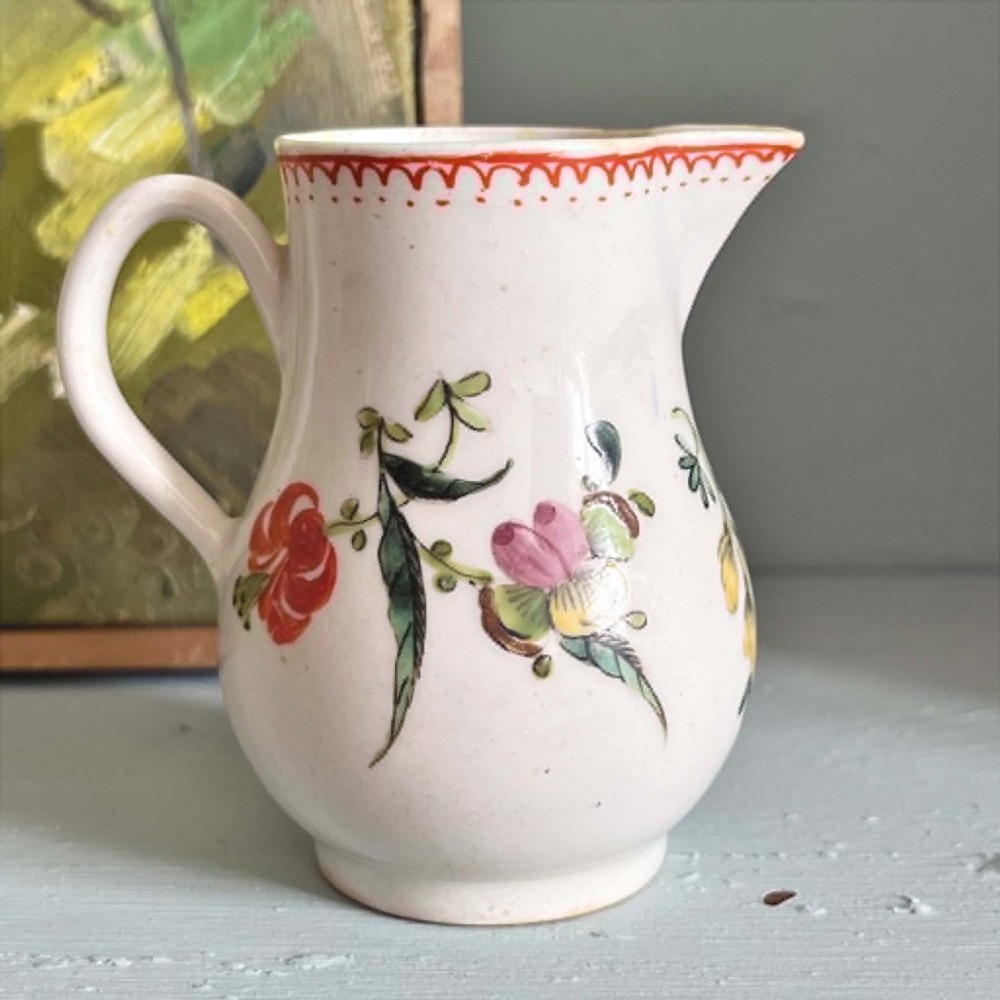 An eighteenth-century Bow soft-paste porcelain sparrowbeak cream jug hand-painted with polychrome floral sprigs and a red painted border. View IX