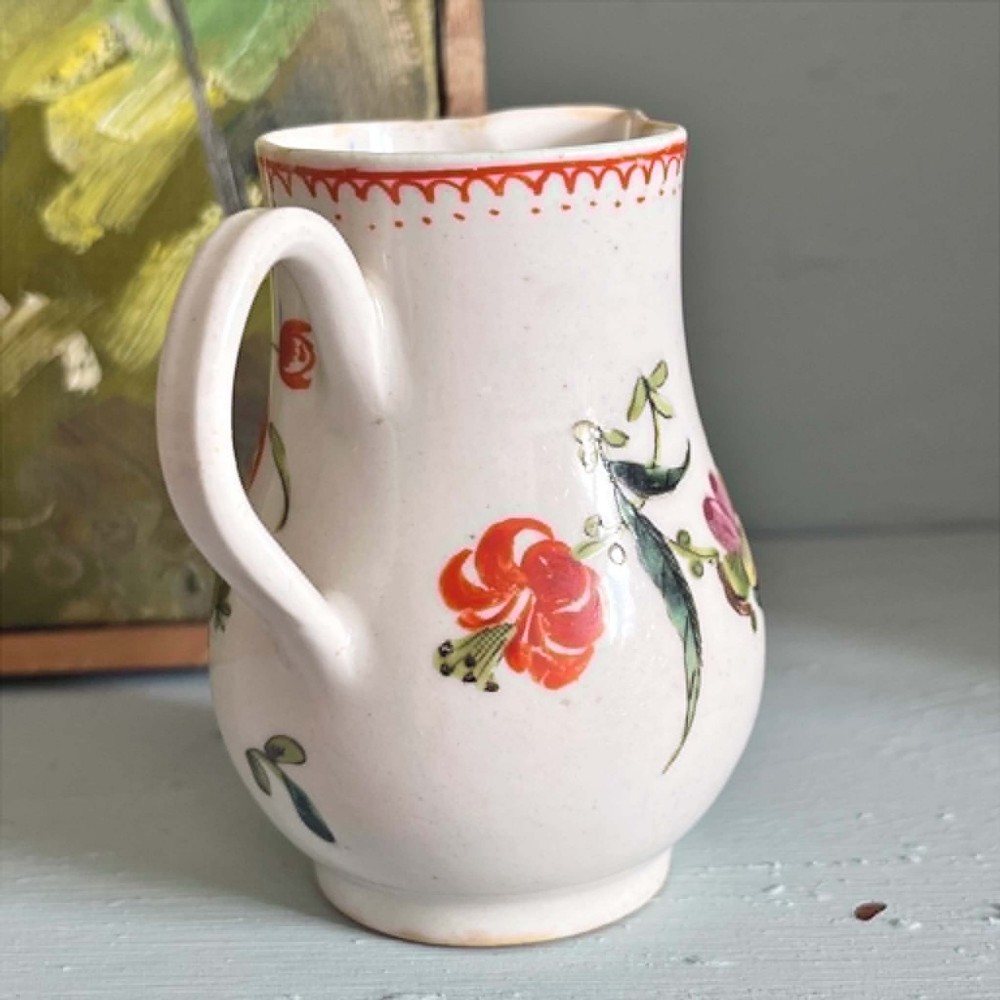 An eighteenth-century Bow soft-paste porcelain sparrowbeak cream jug hand-painted with polychrome floral sprigs and a red painted border. View XIII
