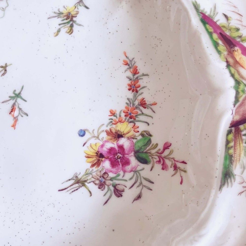 A white soft-paste porcelain moulded dish featuring hand-painted polychrome birds along the scalloped rim and floral sprigs in the centre. View XI