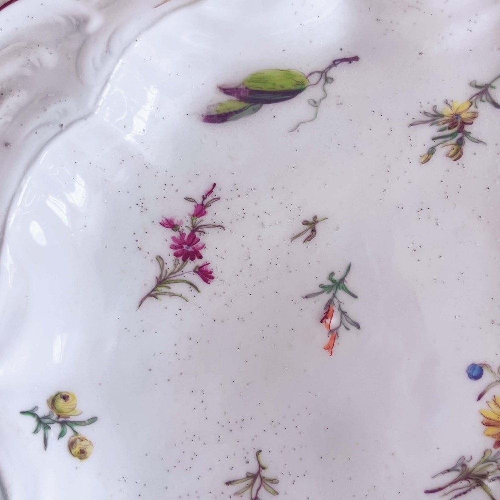A white soft-paste porcelain moulded dish featuring hand-painted polychrome birds along the scalloped rim and floral sprigs in the centre. View XIII