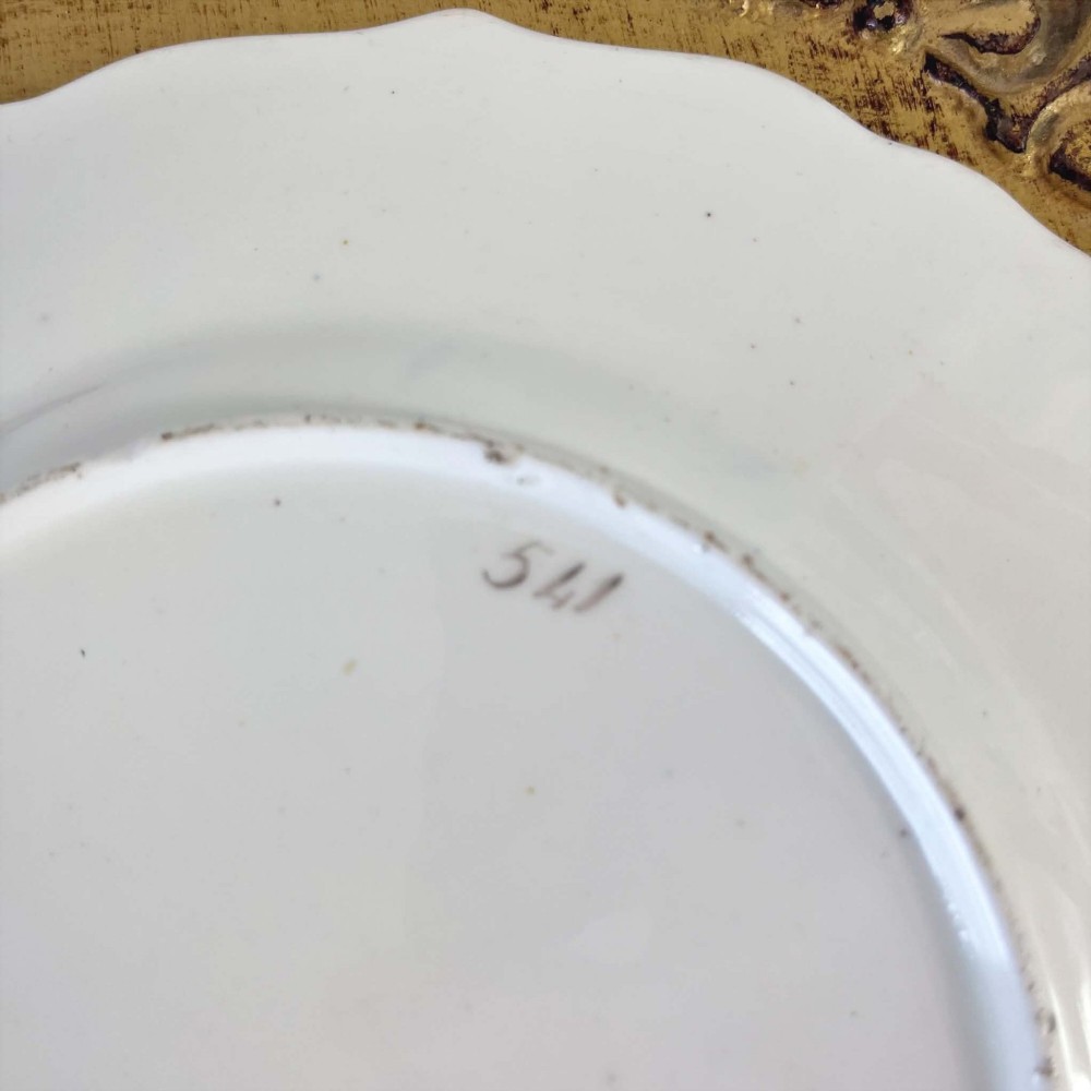 An early nineteenth-century Samuel Alcock porcelain dessert plate featuring a cobalt blue ground, intricate gilt scrolling, and hand-painted floral cartouches. View X