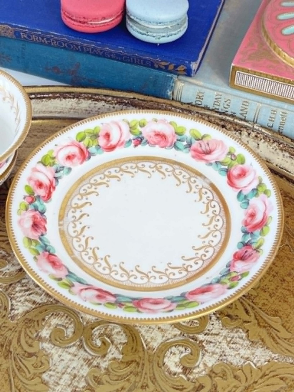 An antique porcelain teacup and matching saucer featuring hand-painted pink cabbage roses, green leaves, and gold scroll decorations. View VII