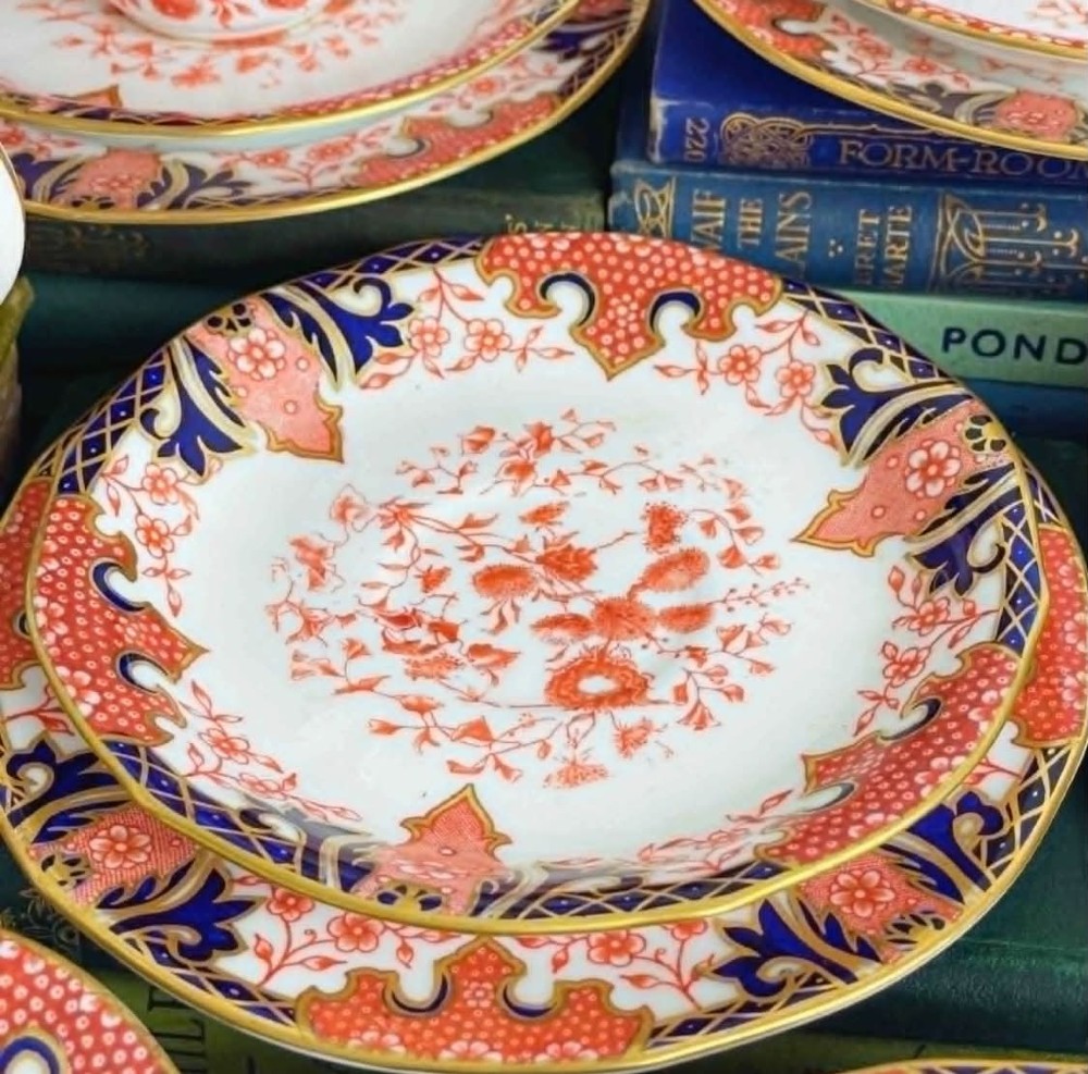 An antique Royal Crown Derby bone china tea set featuring iron red and cobalt blue foliage motifs with gold gilding across cups, saucers, and a cream pitcher. View VII