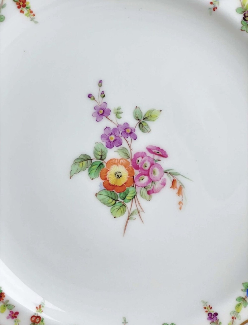 An antique circular porcelain dessert plate featuring a hand-painted central floral spray, delicate floral swags, and a scalloped cobalt blue and gilded rim. View VIII