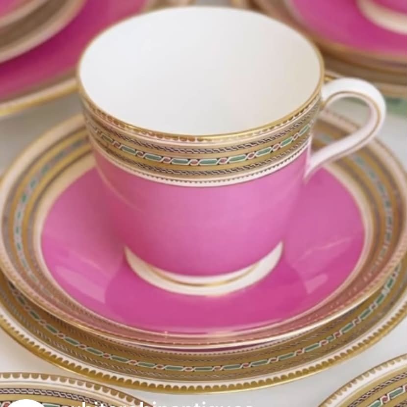 A pink porcelain antique tea trio featuring a teacup, matching saucer, and side plate with gilded geometric borders. View II