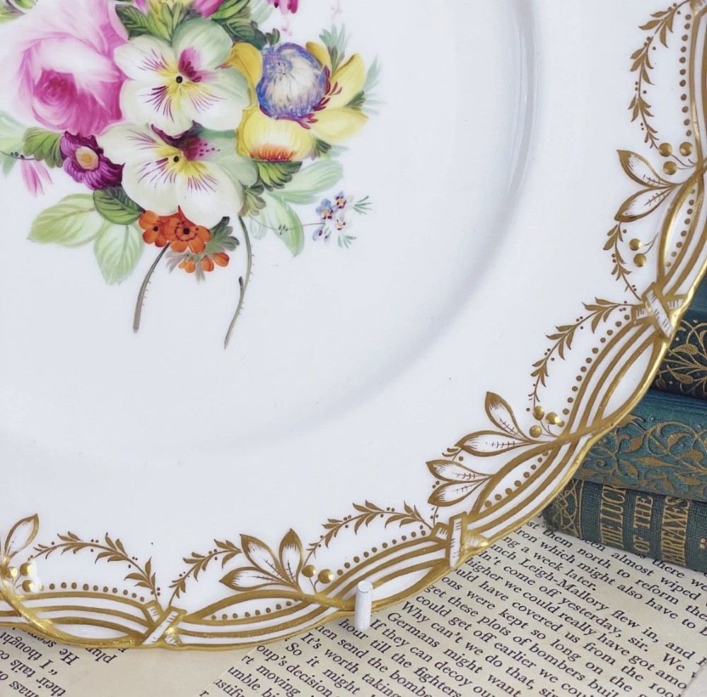 A circular Victorian Coalport porcelain dessert plate featuring a hand-painted central floral motif surrounded by an intricate gilded border. View II