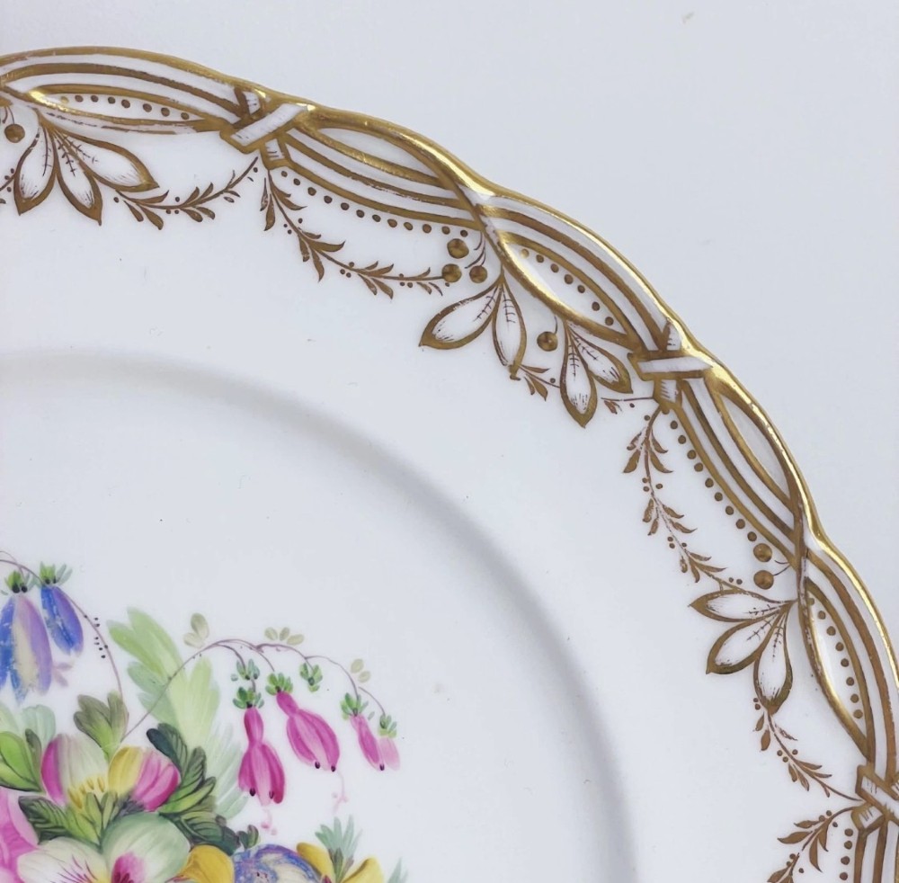 A circular Victorian Coalport porcelain dessert plate featuring a hand-painted central floral motif surrounded by an intricate gilded border. View IV