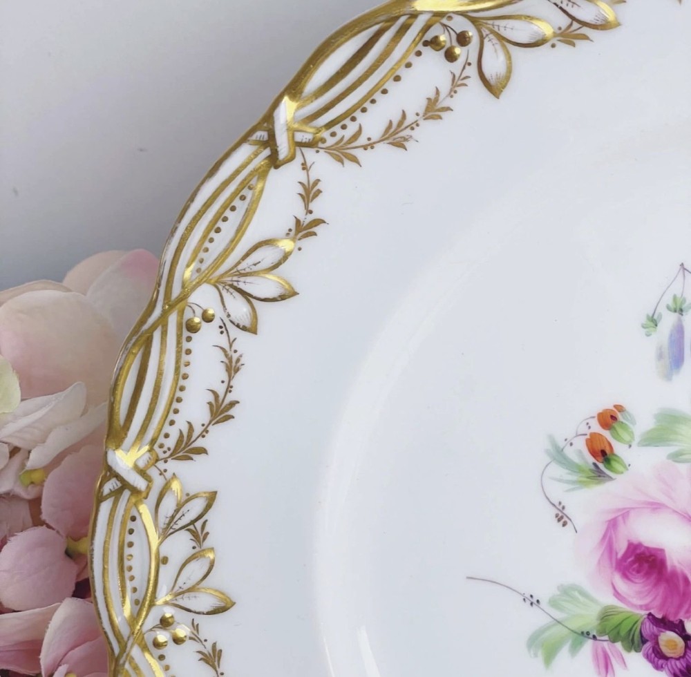 A circular Victorian Coalport porcelain dessert plate featuring a hand-painted central floral motif surrounded by an intricate gilded border. View VI