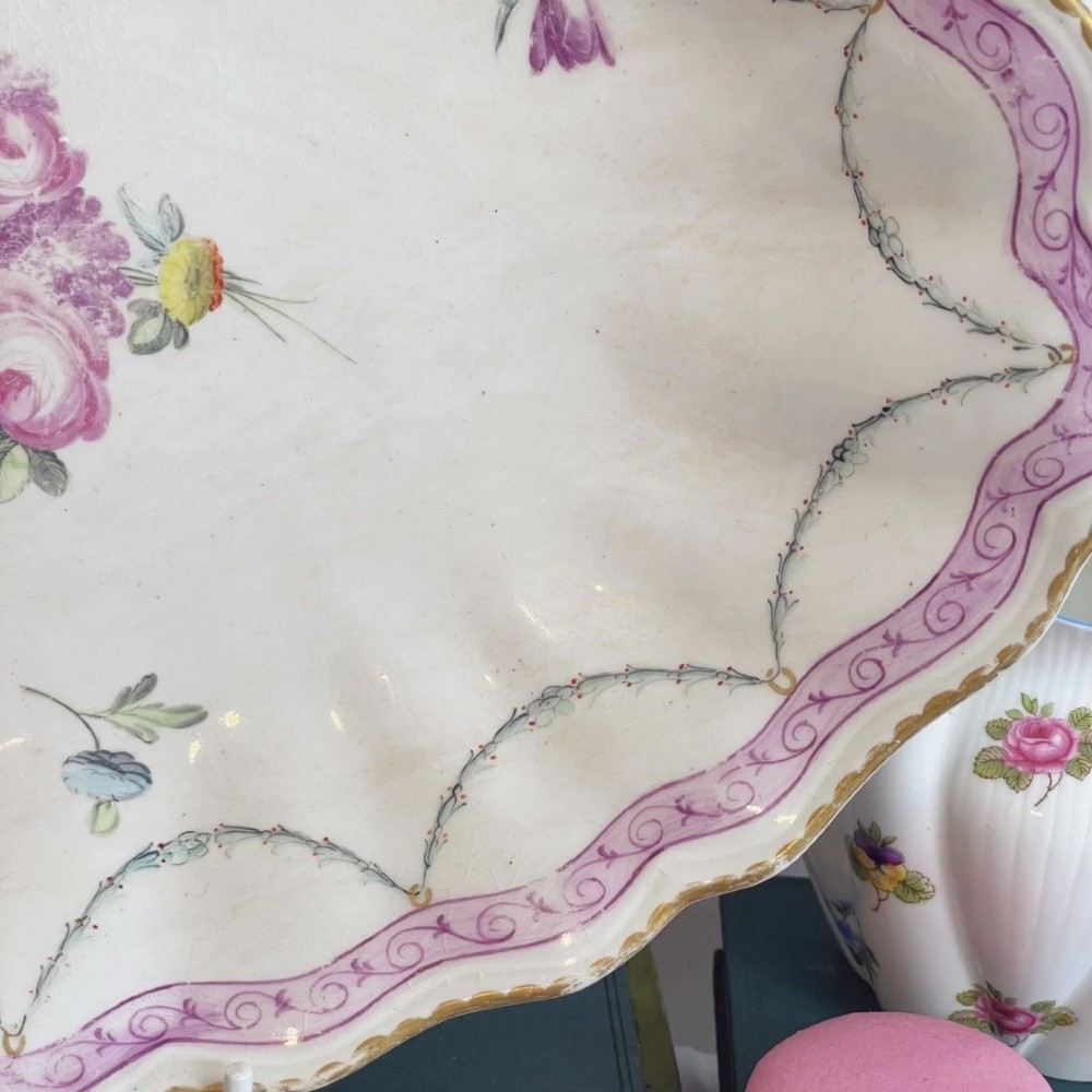 An eighteenth-century oval Derby porcelain serving dish with a scalloped rim, pink scroll border with gilt detailing, and central hand-painted floral spray. View III
