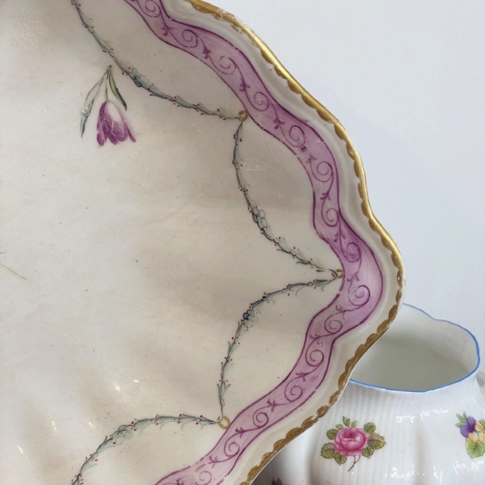 An eighteenth-century oval Derby porcelain serving dish with a scalloped rim, pink scroll border with gilt detailing, and central hand-painted floral spray. View IV