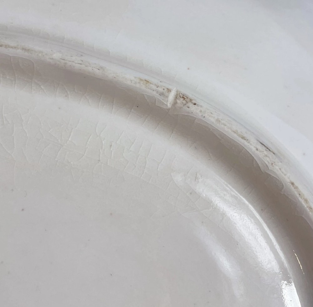 An eighteenth-century oval Derby porcelain serving dish with a scalloped rim, pink scroll border with gilt detailing, and central hand-painted floral spray. View XIV