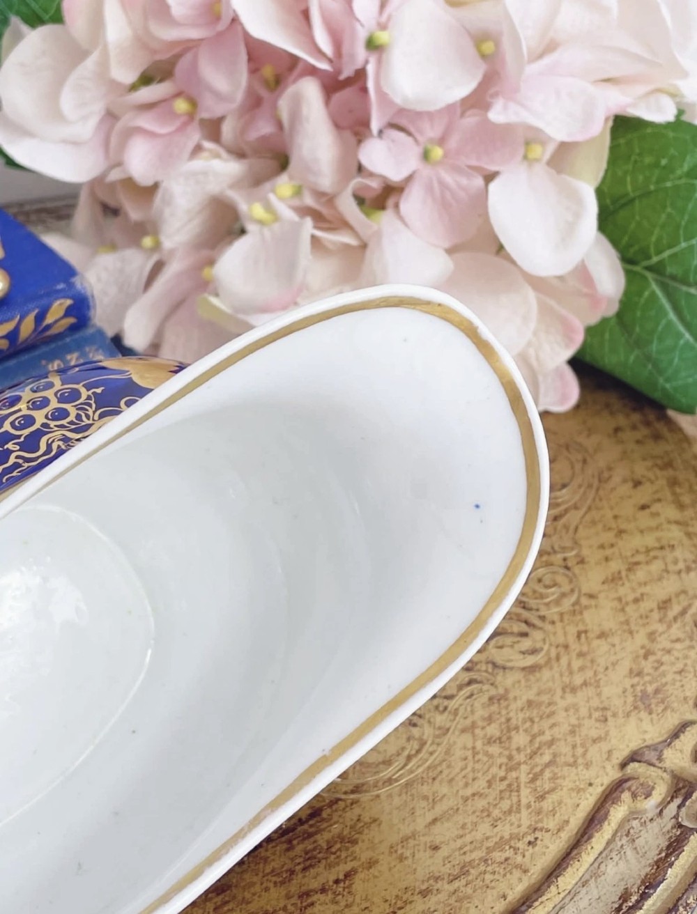 An antique Regency porcelain milk jug decorated with cobalt blue panels, gilt vine details, and hand-painted floral cartouches. View IX