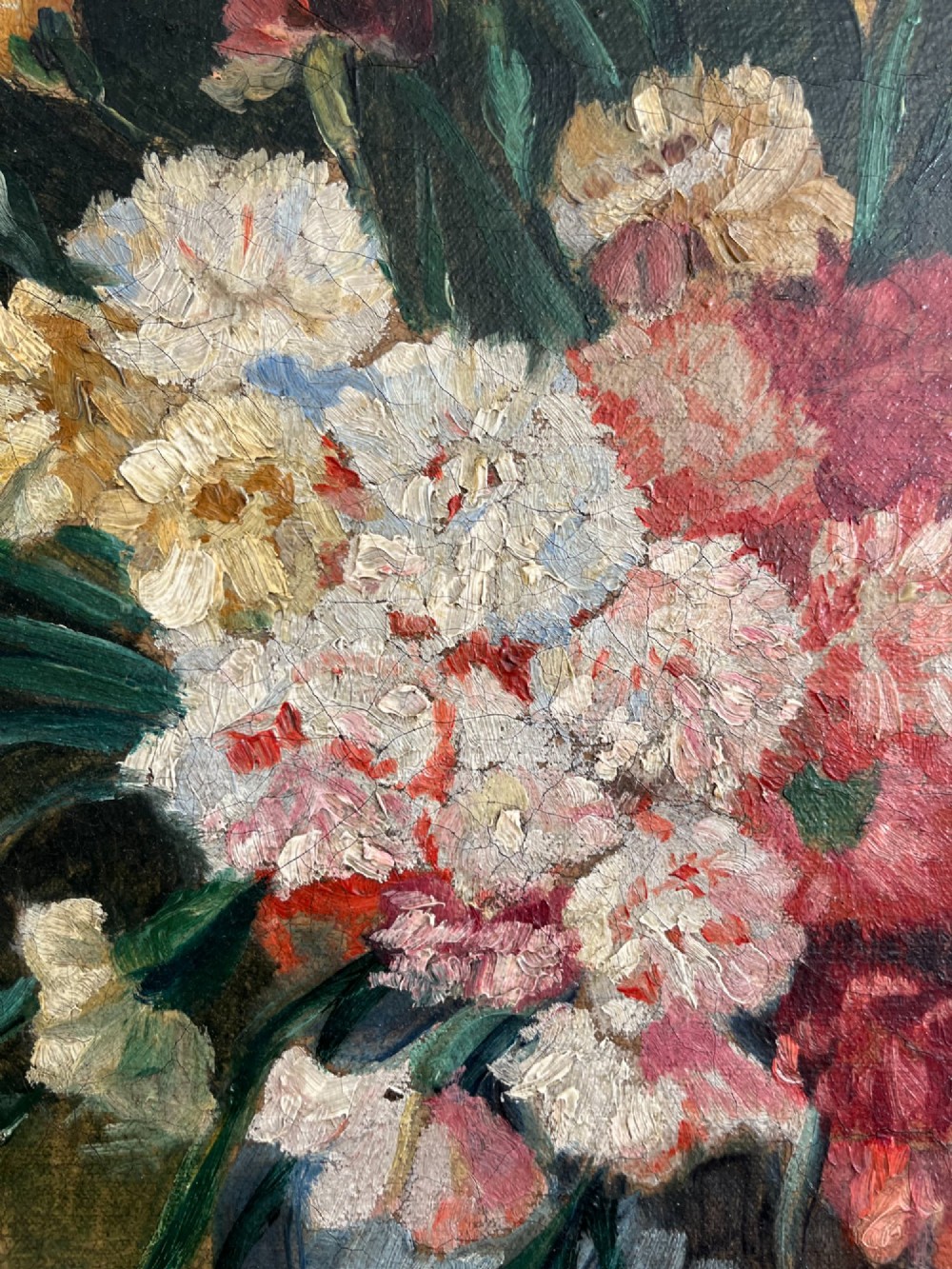 A horizontal oil painting depicting a bouquet of red, pink, yellow, and white carnations in a dark vase, enclosed within a moulded gilt frame. View III