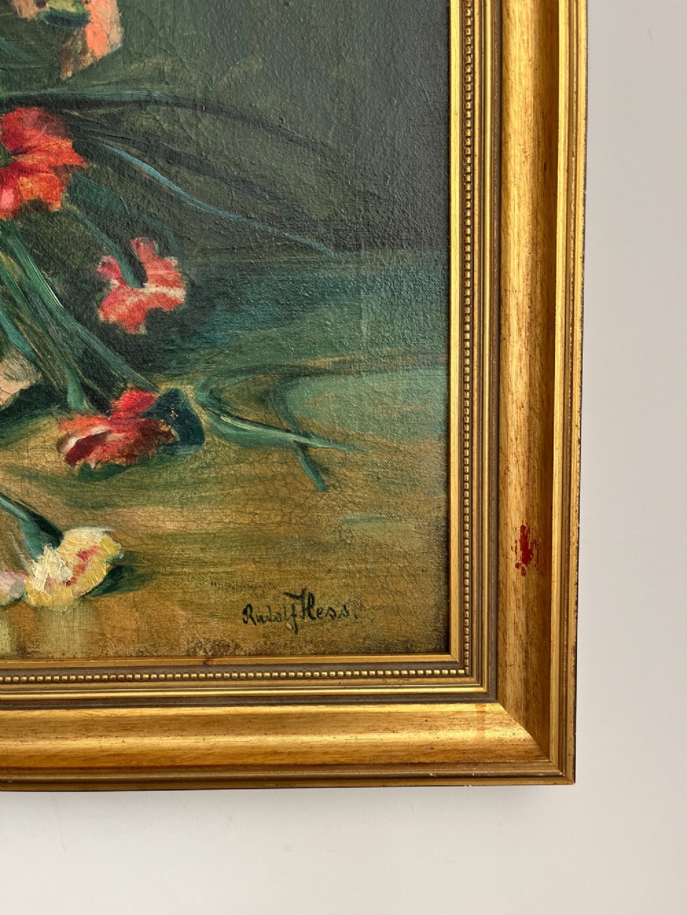 A horizontal oil painting depicting a bouquet of red, pink, yellow, and white carnations in a dark vase, enclosed within a moulded gilt frame. View V