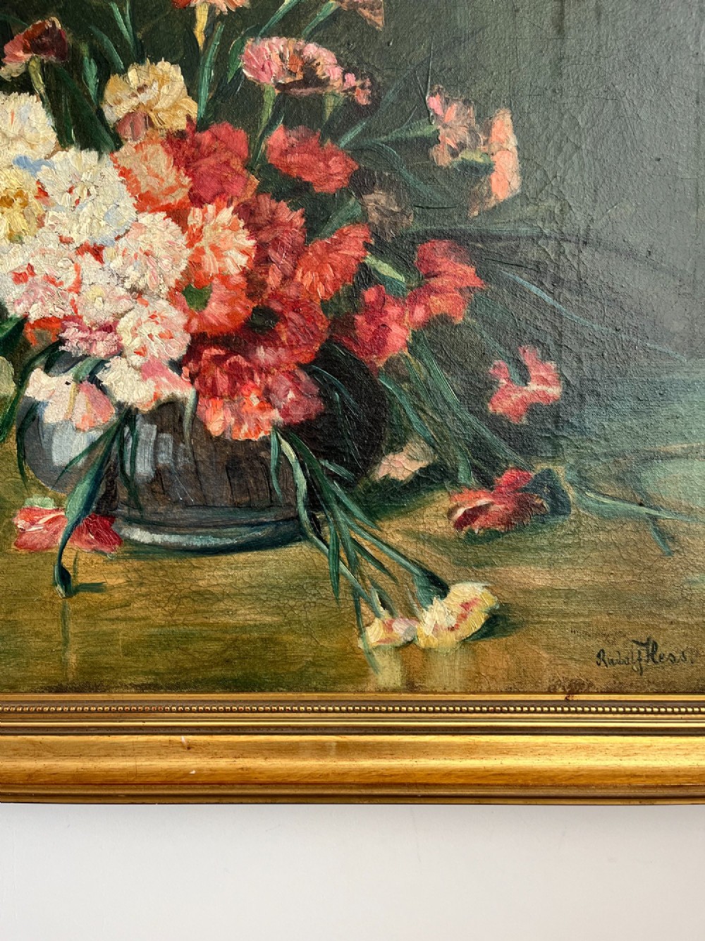 A horizontal oil painting depicting a bouquet of red, pink, yellow, and white carnations in a dark vase, enclosed within a moulded gilt frame. View VII