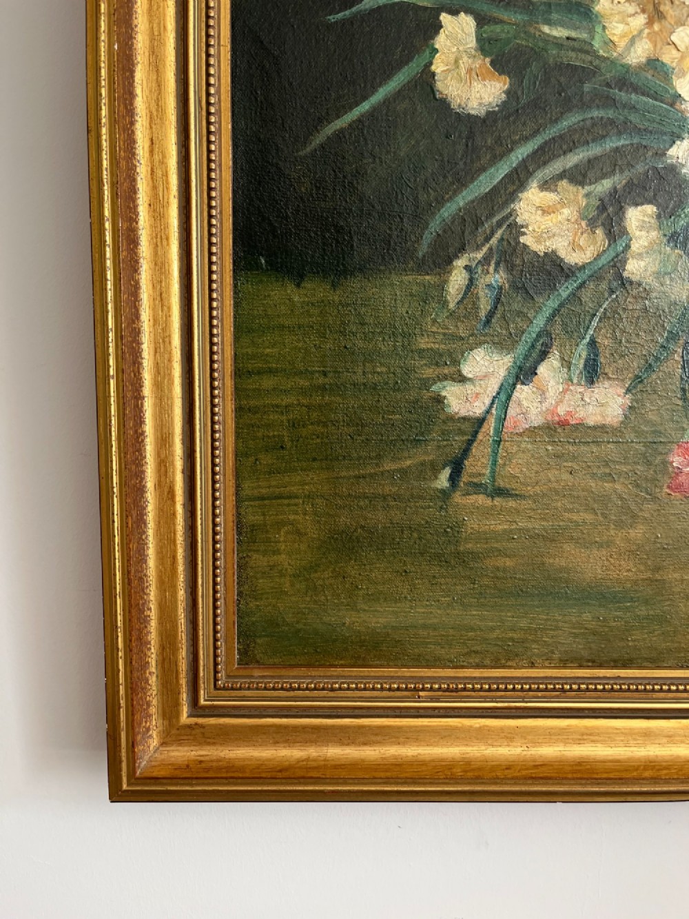 A horizontal oil painting depicting a bouquet of red, pink, yellow, and white carnations in a dark vase, enclosed within a moulded gilt frame. View XI