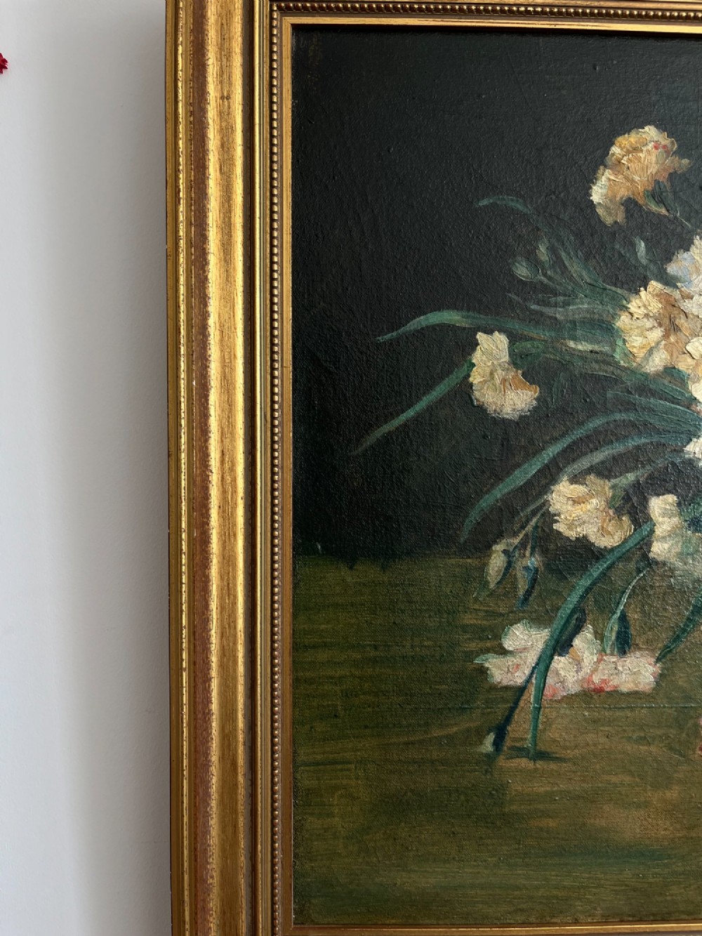 A horizontal oil painting depicting a bouquet of red, pink, yellow, and white carnations in a dark vase, enclosed within a moulded gilt frame. View XII