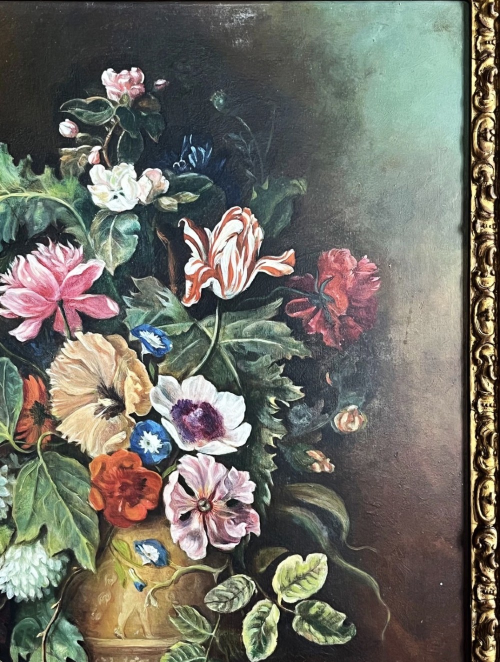 A framed oil painting depicting a floral arrangement in a urn with fruit at the base, housed within an ornate gilt gesso frame. View IX