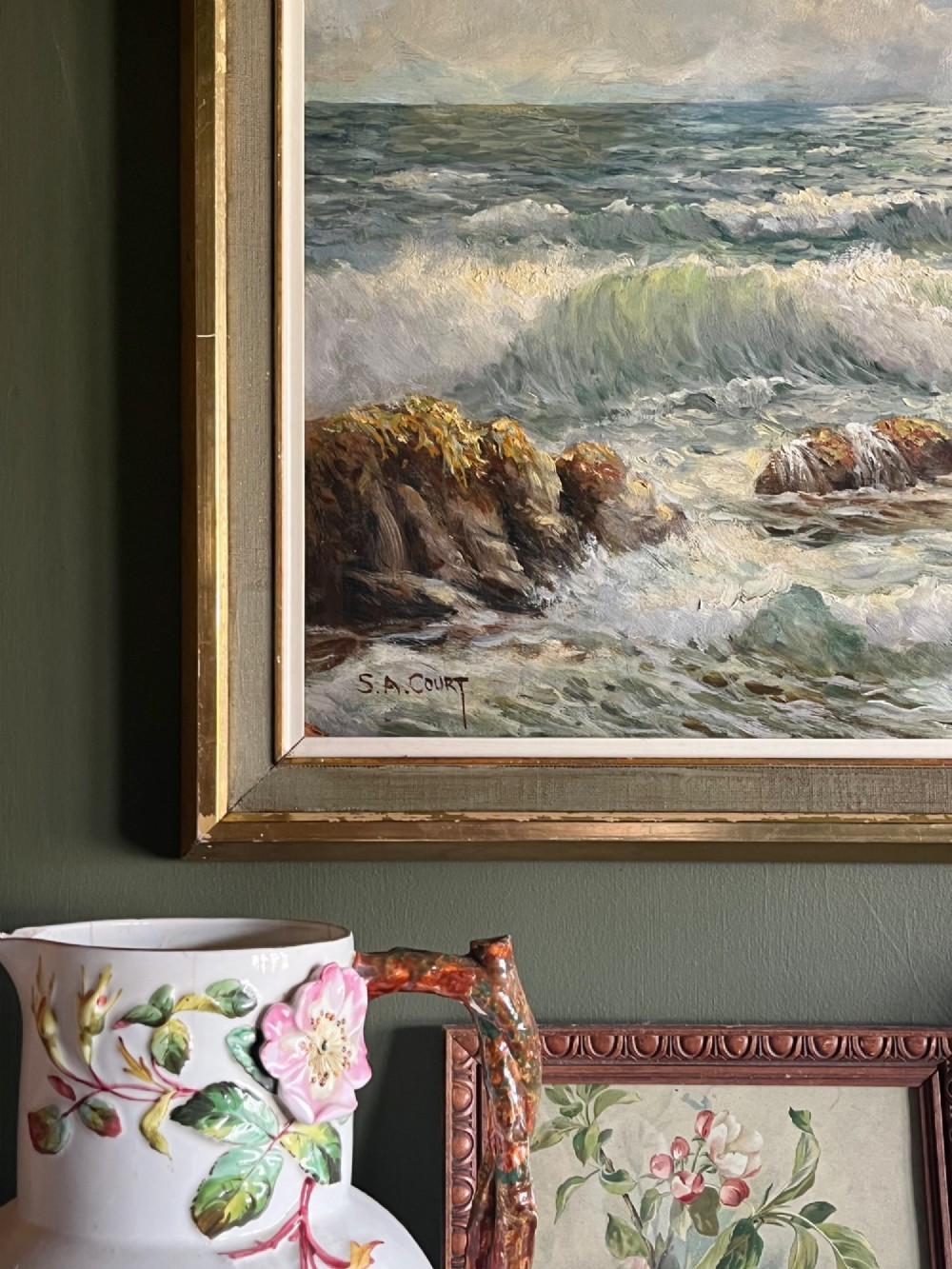 A framed oil painting depicting crashing ocean waves against coastal rocks under an overcast sky, signed by artist Sidney A. Court. View II