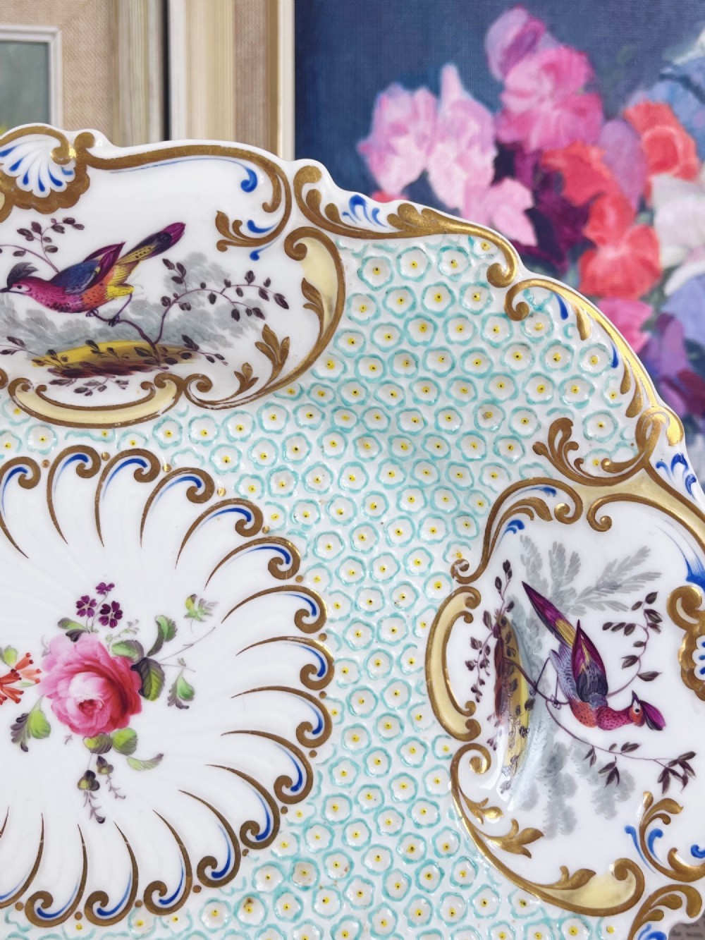 An oval antique porcelain serving dish featuring hand-painted birds in cartouches, a central pink rose, a turquoise pattern ground, and a scalloped gilded rim. View IV