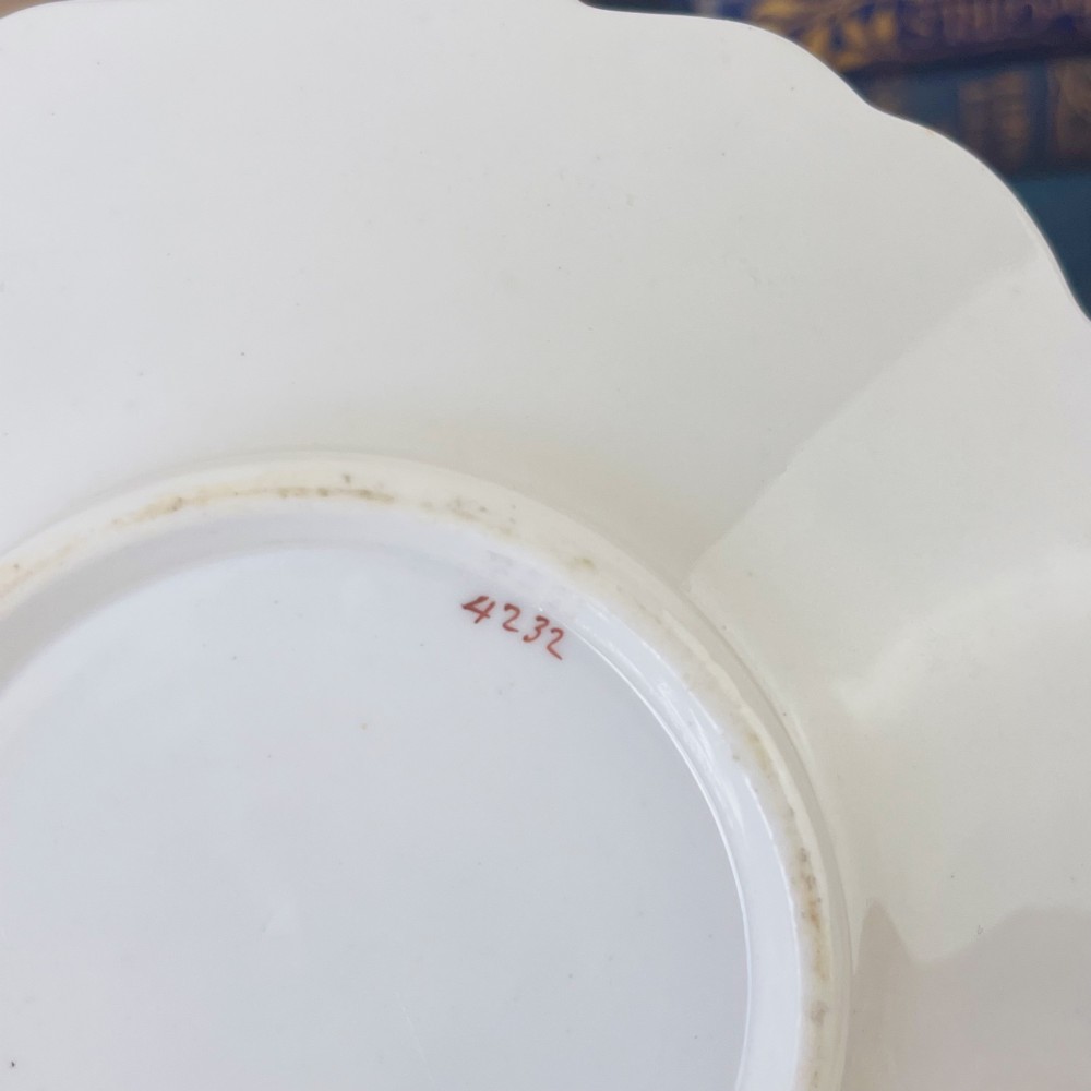 An early nineteenth-century porcelain tea and coffee cup trio featuring hand-painted blue floral motifs and gilt scroll detailing on white ground. View XII