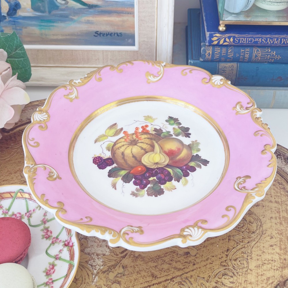 A round early nineteenth-century porcelain footed comport with a rose pink border, gilded shell edge moulding, and a hand-painted central fruit motif. View III
