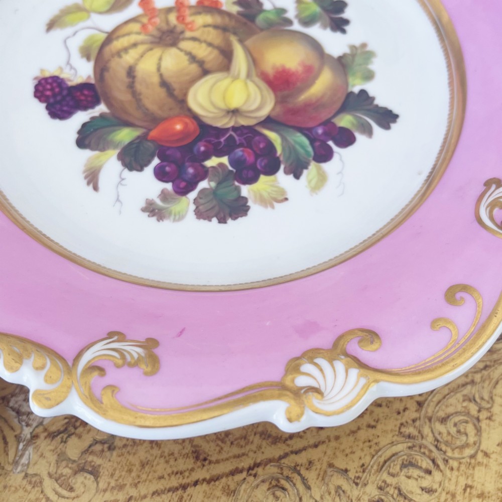 A round early nineteenth-century porcelain footed comport with a rose pink border, gilded shell edge moulding, and a hand-painted central fruit motif. View IV