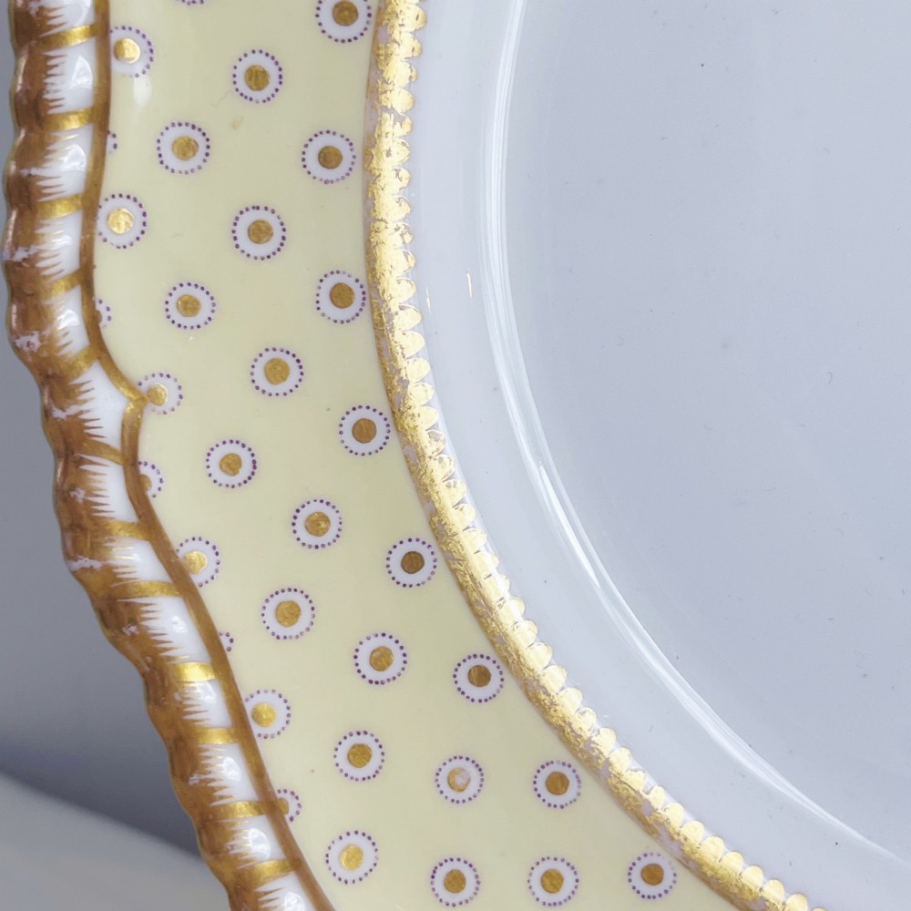 A pair of Regency period Spode Felspar porcelain dessert plates featuring pale yellow patterned rims with gilded scalloped edges and central hand-painted floral sprays. View VIII