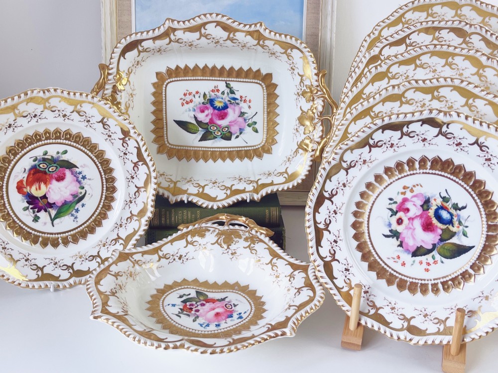 An eight-piece Regency Grainger Lee & Co porcelain dessert service with gold leaf borders and hand-painted floral centres against a white ground.