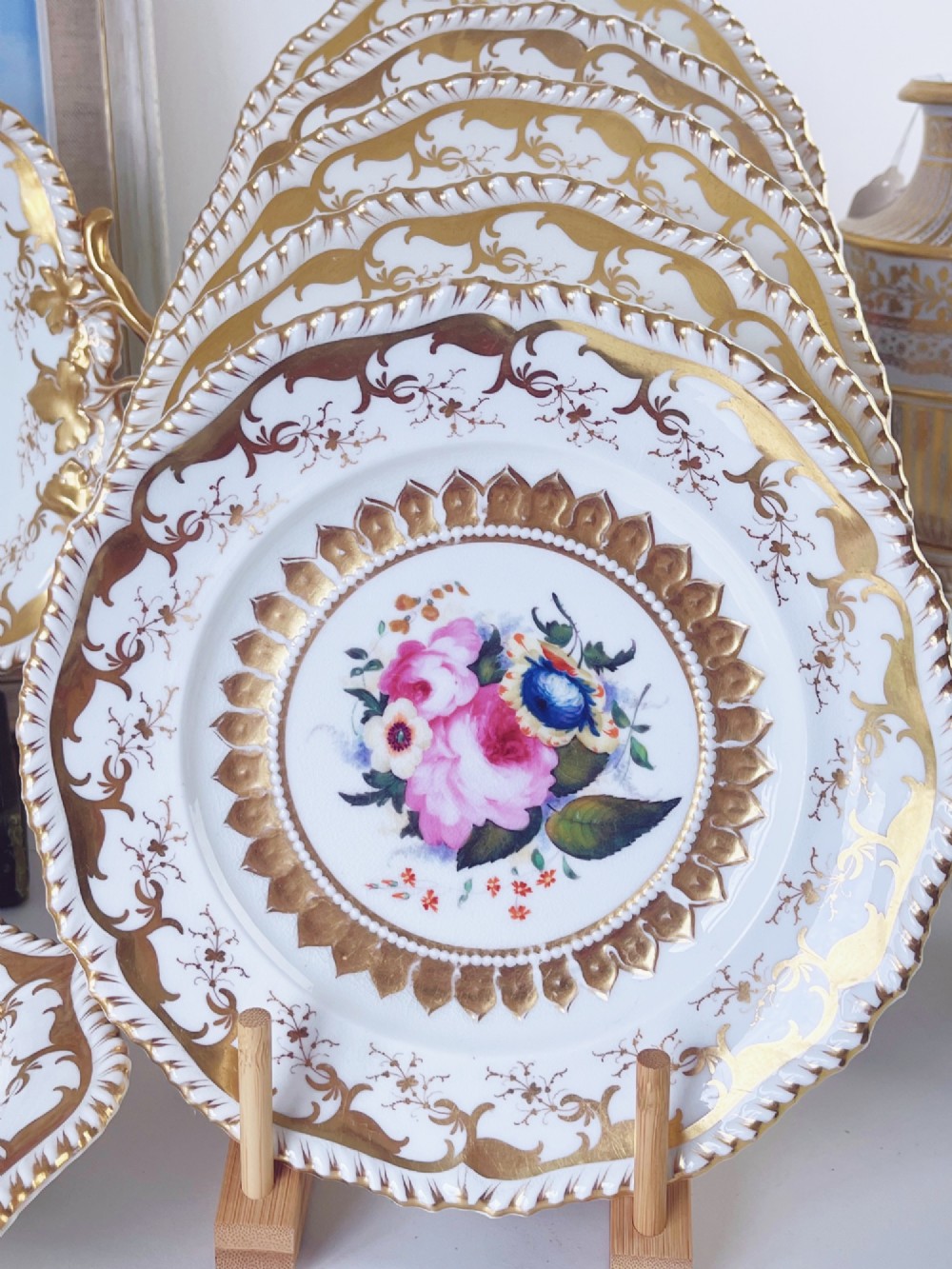 An eight-piece Regency Grainger Lee & Co porcelain dessert service with gold leaf borders and hand-painted floral centres against a white ground. View IV