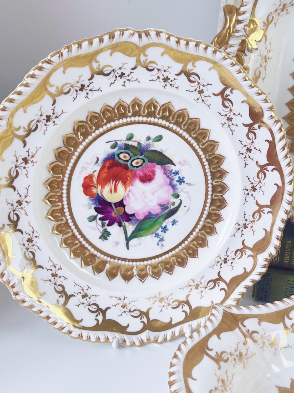 An eight-piece Regency Grainger Lee & Co porcelain dessert service with gold leaf borders and hand-painted floral centres against a white ground. View VIII