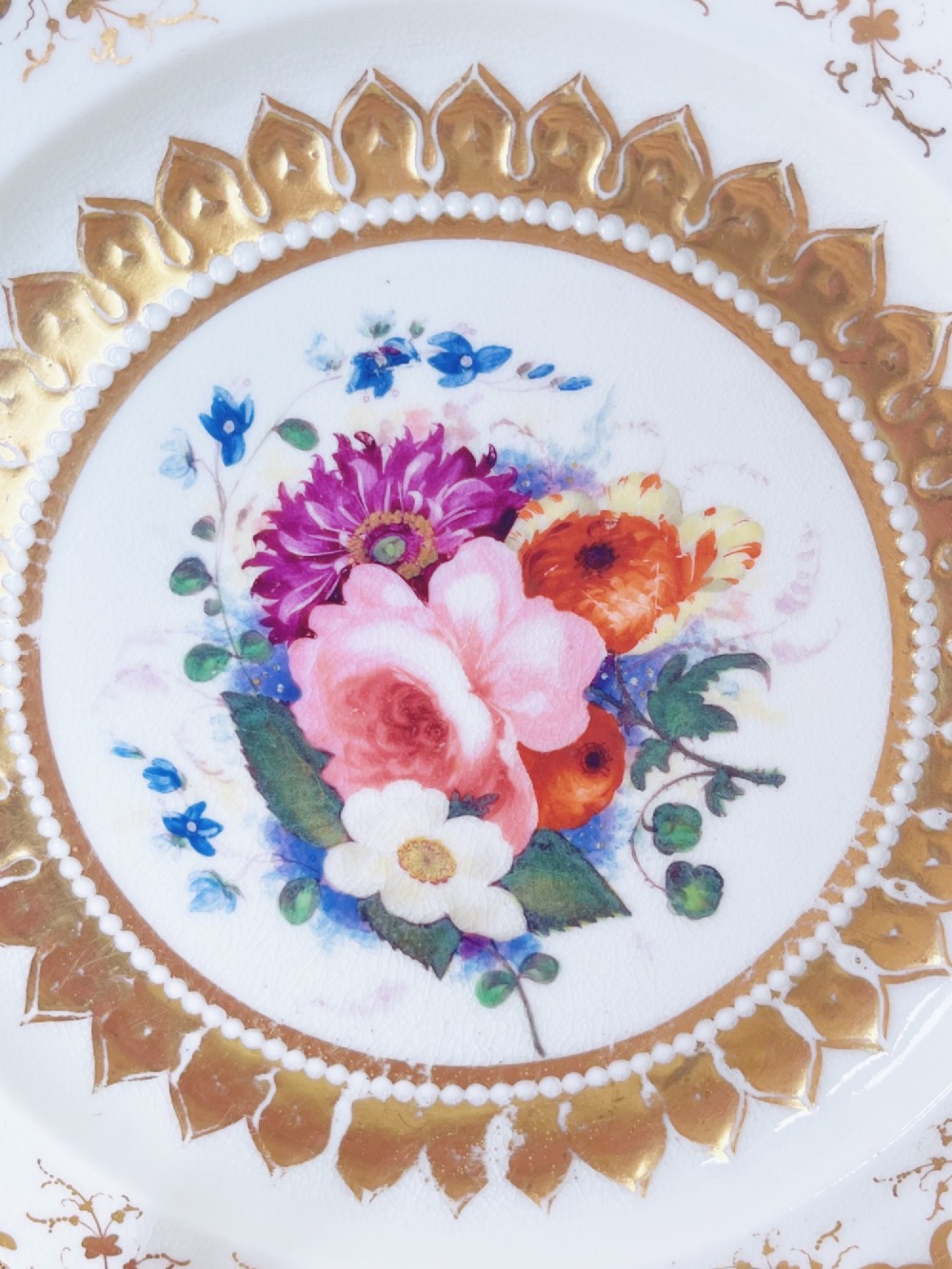 An eight-piece Regency Grainger Lee & Co porcelain dessert service with gold leaf borders and hand-painted floral centres against a white ground. View X