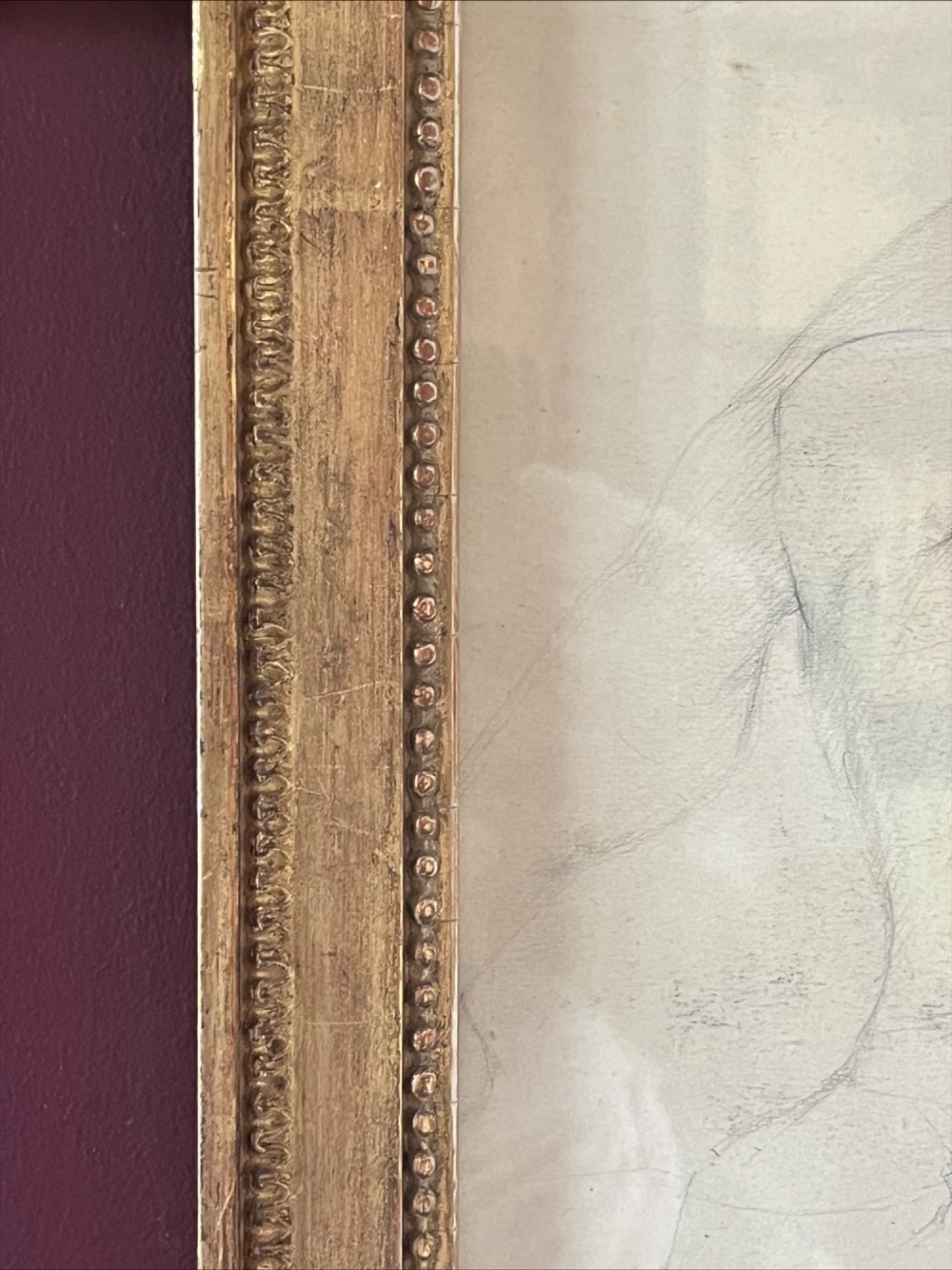 A pencil life drawing depicting a seated female nude, displayed inside a gilded wood frame with decorative beaded details. View III