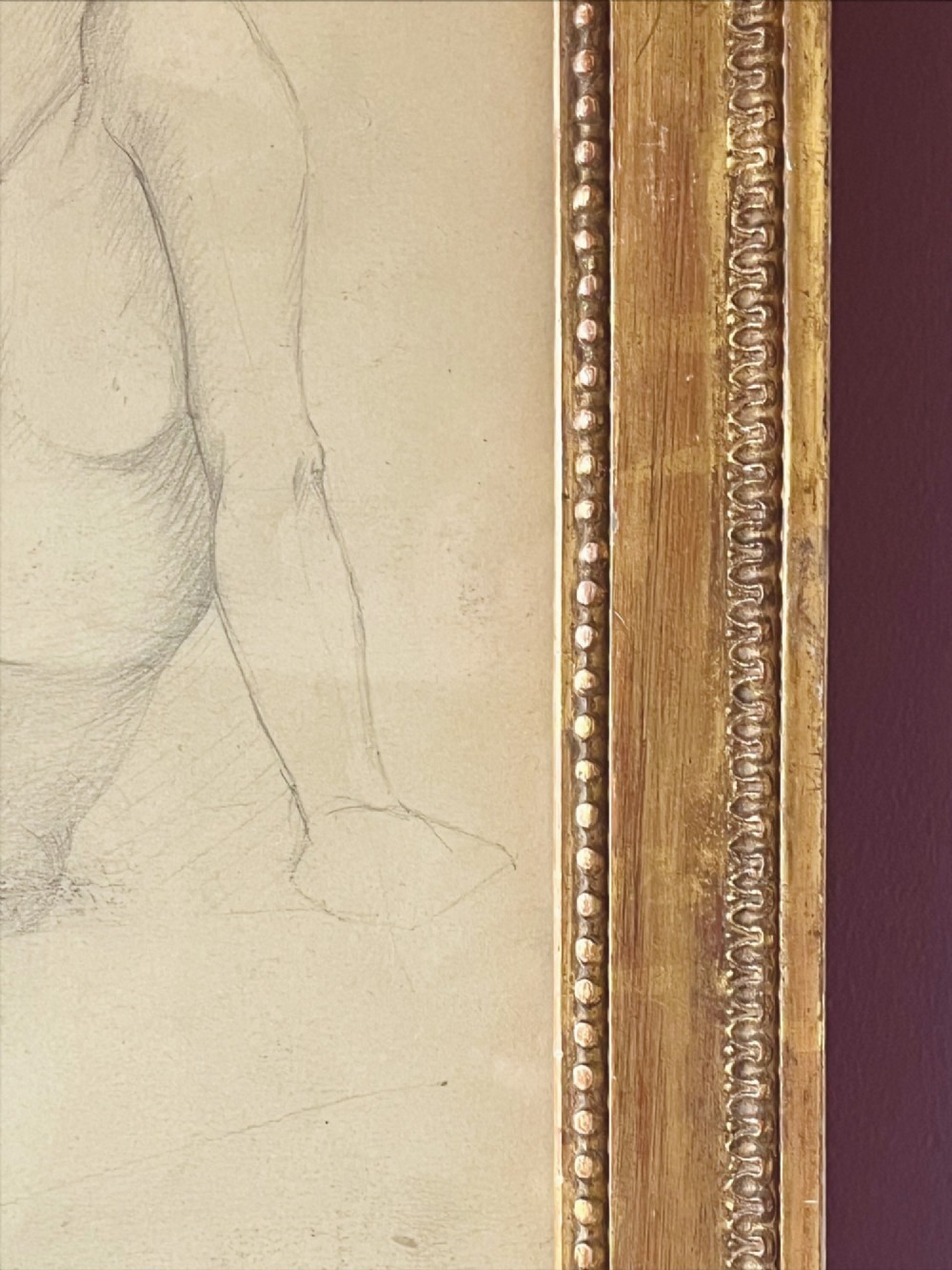 A pencil life drawing depicting a seated female nude, displayed inside a gilded wood frame with decorative beaded details. View VIII