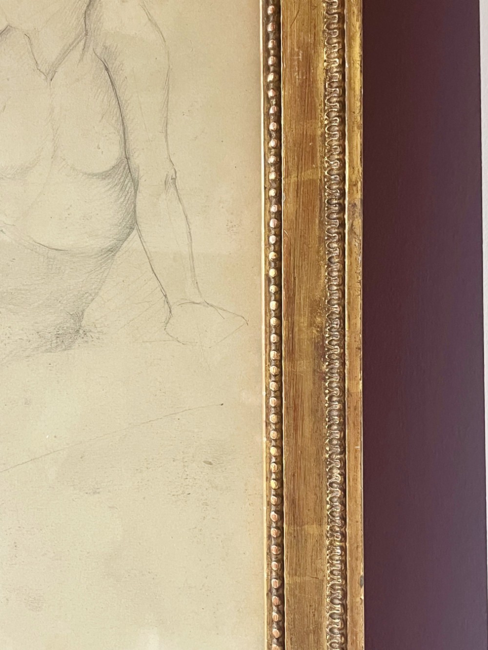 A pencil life drawing depicting a seated female nude, displayed inside a gilded wood frame with decorative beaded details. View IX