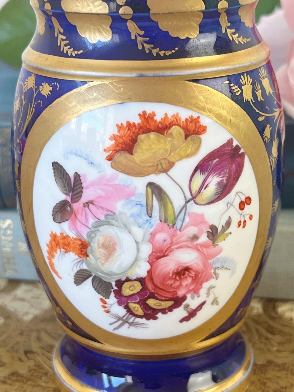 A small cylindrical Regency Coalport porcelain spill vase featuring a cobalt blue ground with gold leaf accents and a central oval medallion hand-painted with flowers. View II