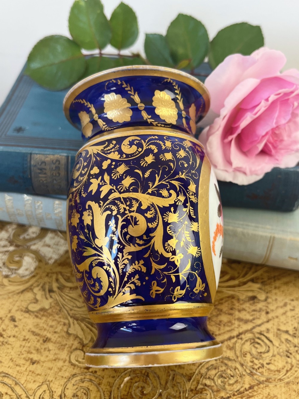 A small cylindrical Regency Coalport porcelain spill vase featuring a cobalt blue ground with gold leaf accents and a central oval medallion hand-painted with flowers. View III