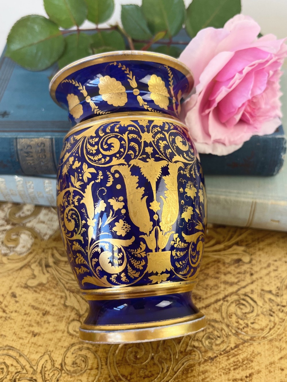A small cylindrical Regency Coalport porcelain spill vase featuring a cobalt blue ground with gold leaf accents and a central oval medallion hand-painted with flowers. View IV