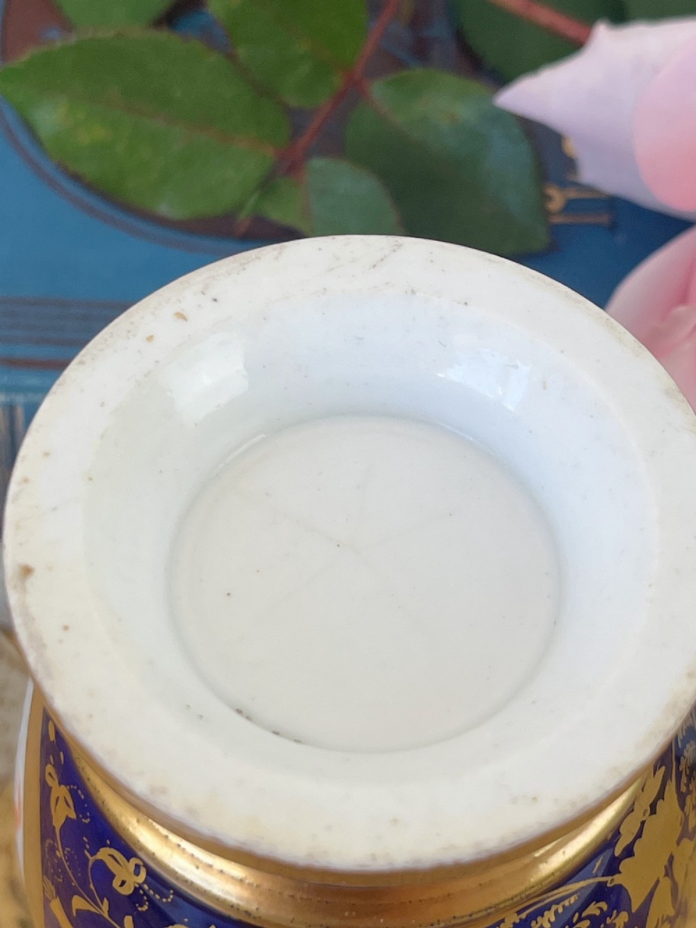 A small cylindrical Regency Coalport porcelain spill vase featuring a cobalt blue ground with gold leaf accents and a central oval medallion hand-painted with flowers. View VII