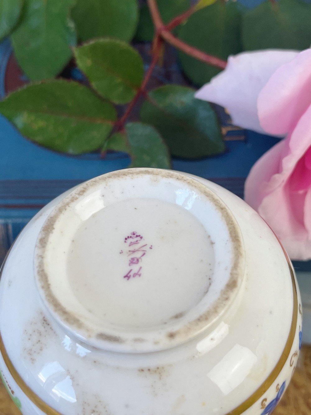 A small Georgian porcelain bud vase featuring a rounded base and narrow neck with hand-painted polychrome scroll motifs and gilded bands. View V