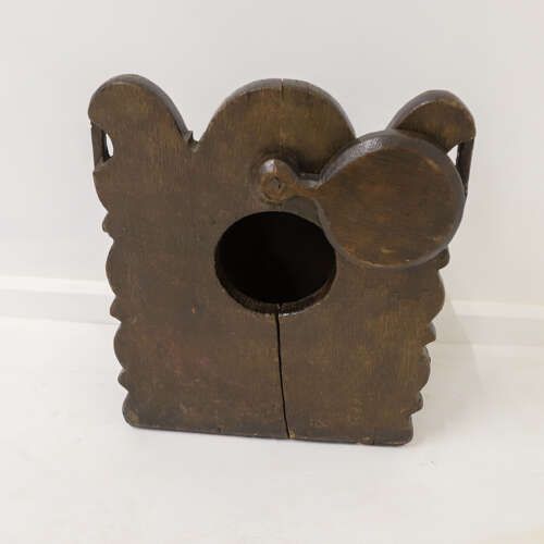 fig 2. A dark oak wall-mounted salt box featuring shaped decorative edges, a circular hanging aperture, and a hinged lid.
