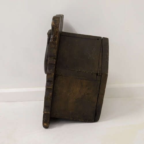 fig 7. A dark oak wall-mounted salt box featuring shaped decorative edges, a circular hanging aperture, and a hinged lid.