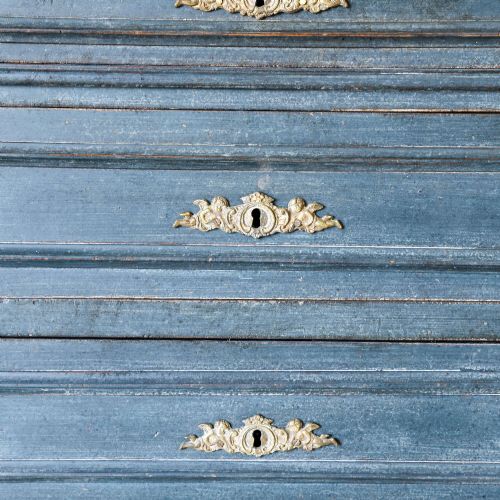 fig 4. A late 19th-century French Louis XVI Revival chest of drawers painted in slate blue with four drawers featuring decorative brass hardware.