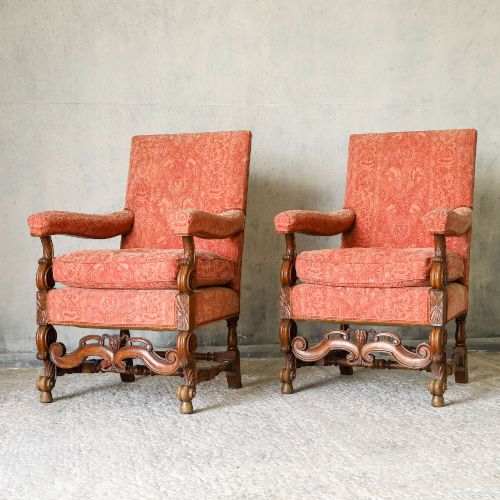 fig 4. A pair of late nineteenth-century French Renaissance Revival oak armchairs upholstered in terracotta patterned fabric with carved scrolled stretchers and turned legs.