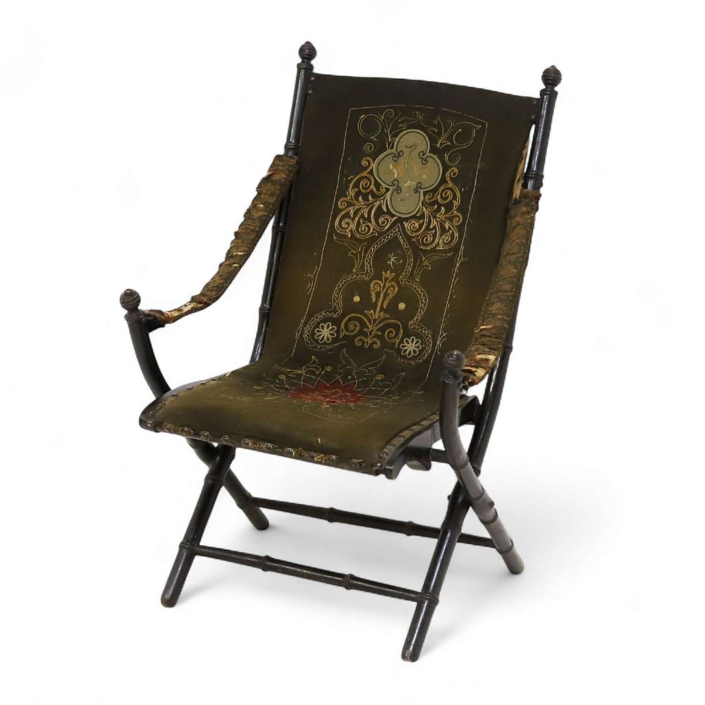 A 19th-century French Louis Philippe folding campaign chair featuring an ebonised faux-bamboo frame and an embroidered dark green fabric sling back and seat.