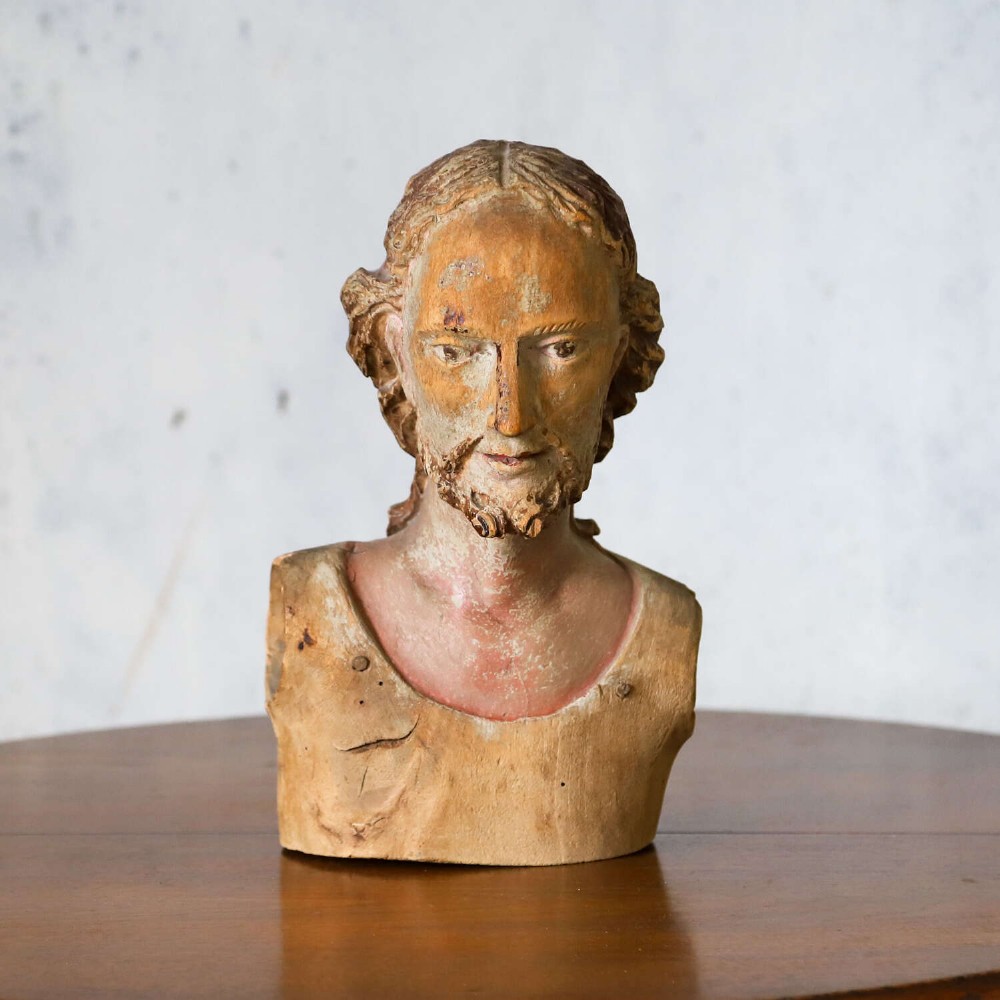 An 18th-century carved olive wood bust depicting Christ with visible traces of original polychrome paint. View II