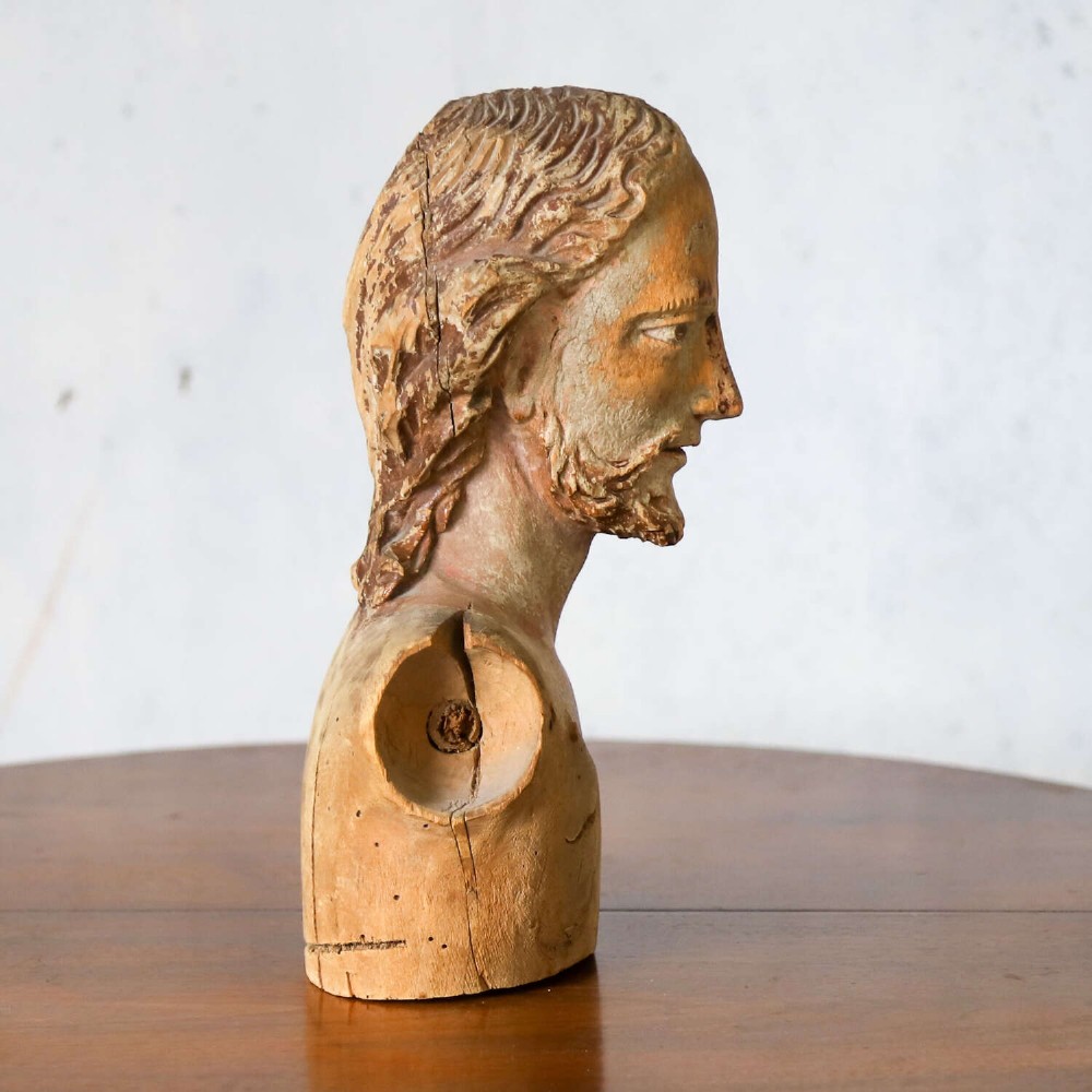 An 18th-century carved olive wood bust depicting Christ with visible traces of original polychrome paint. View V