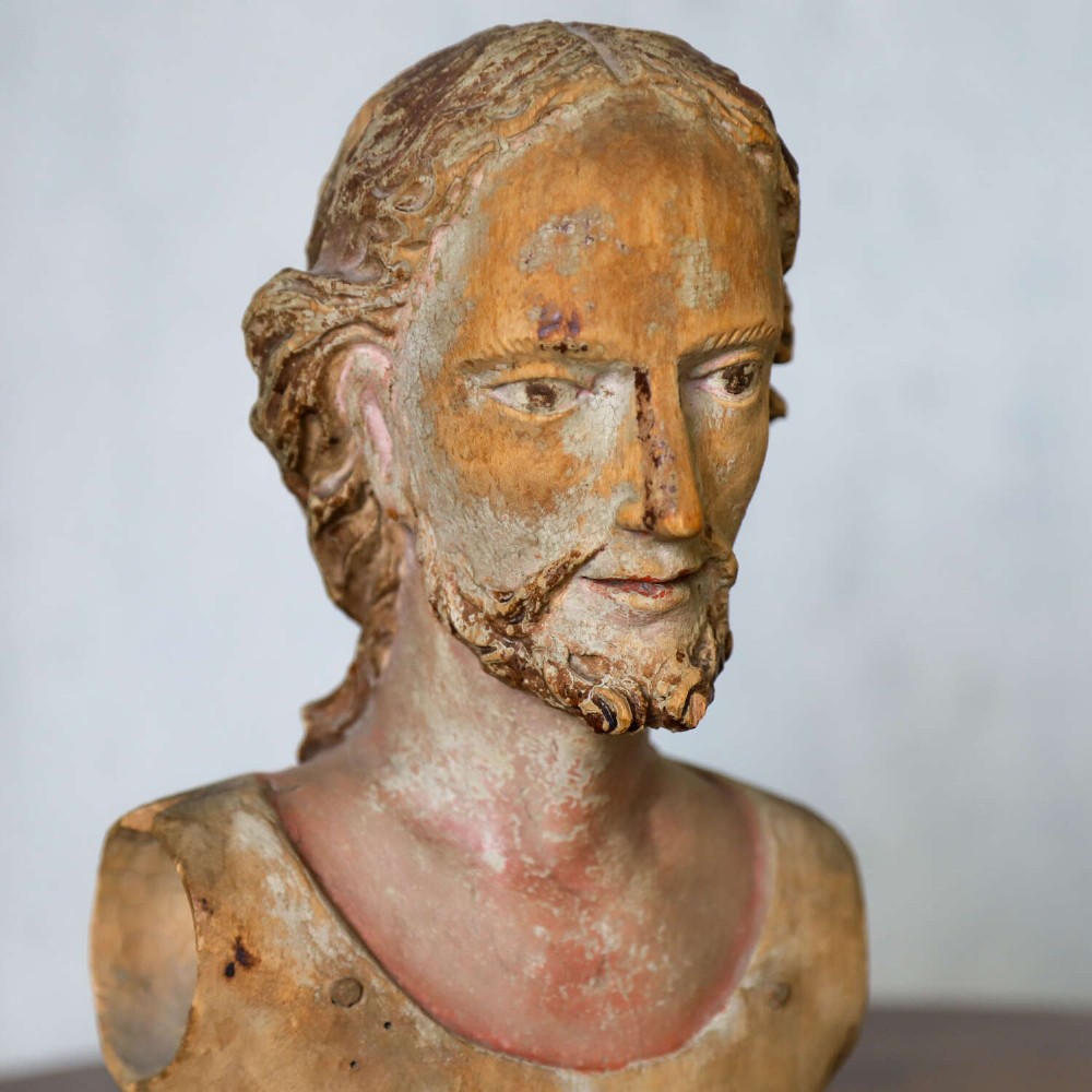 An 18th-century carved olive wood bust depicting Christ with visible traces of original polychrome paint. View VIII