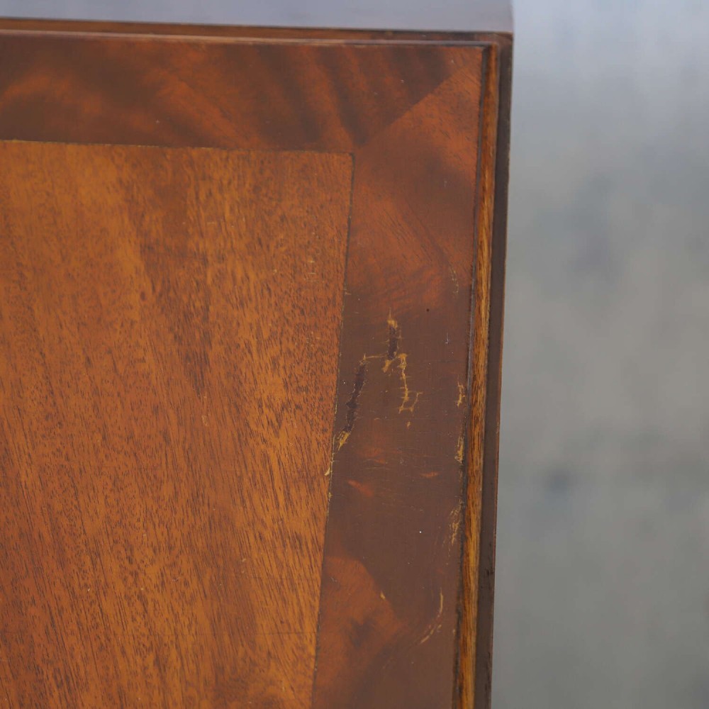 An English 1930s flame mahogany slant-front writing bureau featuring four lower drawers and brass handles. View VII